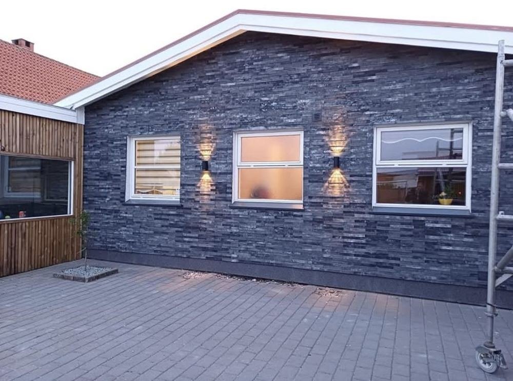 Akmens faktūros plytelės su vakariniu apšvietimu